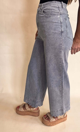 High waisted light wash denim with laser cut embroidery at pant hem
